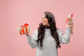 Image showing Woman with big beautiful smile holding colorful gift boxes.