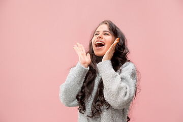 Image showing Isolated on pink young casual woman shouting at studio