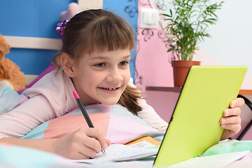 Image showing Happy girl studying online at home using distance learning