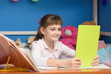 Image showing The girl has done homework and communicates with friends via video calling.