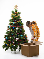 Image showing Girl puts Christmas decorations in a storage box