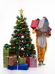 Image showing Girl holding a bunch of gifts standing by the New Year tree