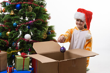 Image showing Girl pulls Christmas ball out of the box