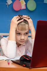 Image showing Girl can not solve the difficult task of studying online