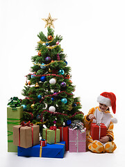 Image showing Girl unpacks a Christmas present at the Christmas tree