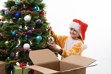 Image showing Girl hangs a Christmas ball on the Christmas tree