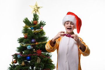 Image showing Girl has fun holding a candy-shaped Christmas toy