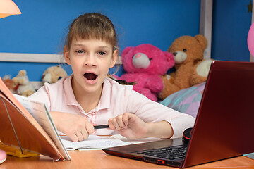 Image showing Girl yawns from boring distance learning