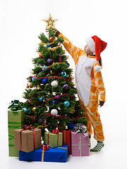 Image showing Girl puts a tip on top of the Christmas tree