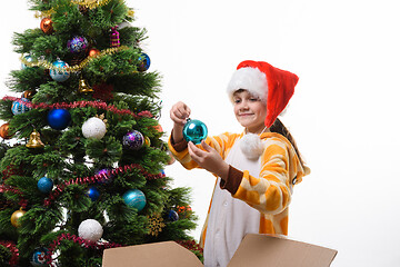 Image showing The girl took a Christmas toy out of the box