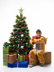 Image showing Girl hugs a New Year\'s gift while sitting on a large storage box