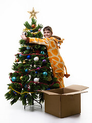 Image showing Girl hugs Christmas tree and looks in the frame