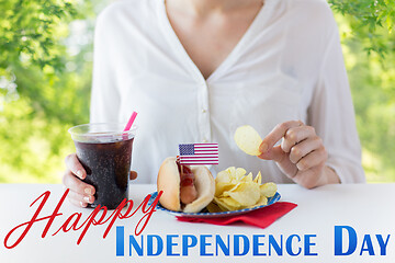 Image showing close up of woman eating chips, hot dog and cola