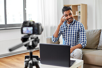 Image showing male blogger with camera videoblogging at home