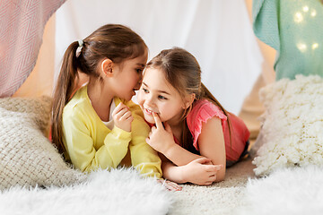 Image showing happy girls lying in kids tent and talking at home