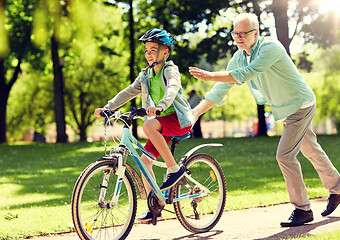 Image showing grandfather and boy with bicycle at summer park