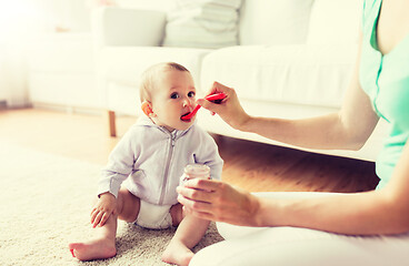 Image showing mother with spoon feeding little baby at home