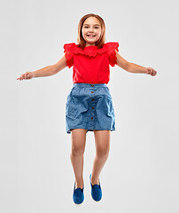 Image showing happy smiling girl in red shirt and skirt jumping