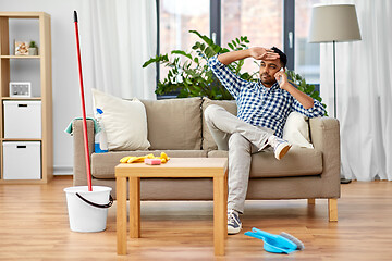 Image showing man calling on smartphone after cleaning home