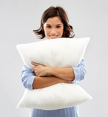 Image showing happy young woman in pajama hugging pillow