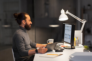 Image showing creative man with computer working at night office