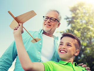 Image showing senior man and boy with toy airplane over sky