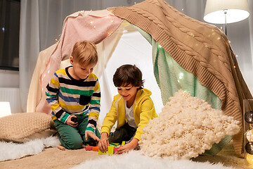 Image showing boys playing toy blocks in kids tent at home