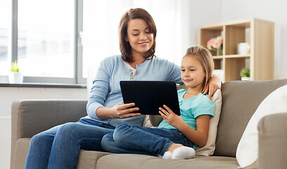 Image showing happy mother and daughter with tablet pc at home