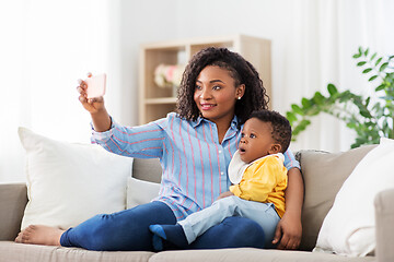 Image showing african mother with baby son taking selfie at home