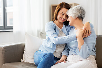 Image showing senior mother with adult daughter hugging at home