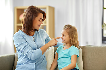 Image showing mother and daughter sitting on sofa at home