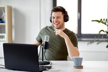 Image showing man with laptop and microphone at home office