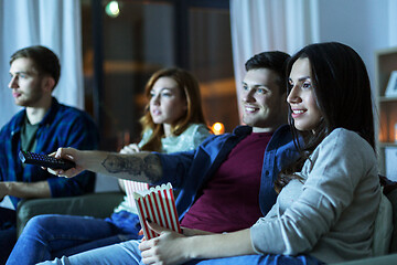 Image showing friends with popcorn watching tv at home