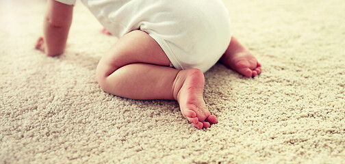 Image showing little baby in diaper crawling on floor at home