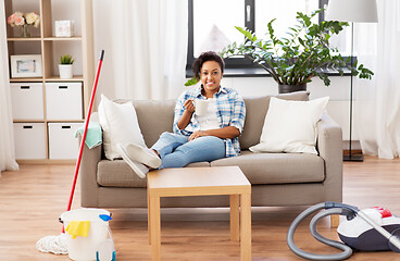 Image showing woman drinking coffee or tea after cleaning home