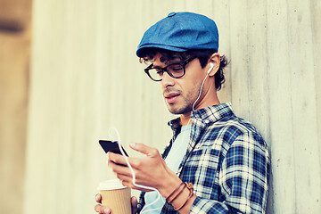 Image showing man with earphones and smartphone drinking coffee