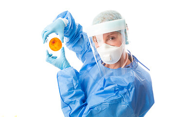 Image showing Pathology sceintist in biosecurity suit and PPE holds up a petri