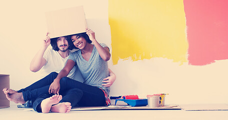 Image showing young multiethnic couple playing with cardboard boxes