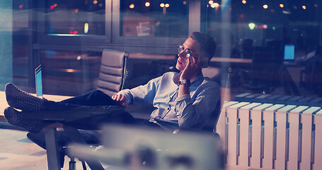 Image showing businessman sitting with legs on desk at office