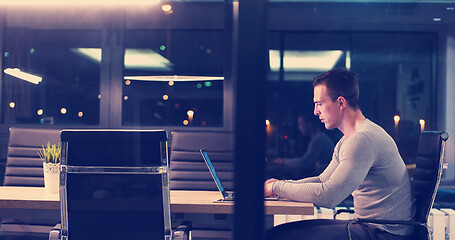 Image showing man working on laptop in dark office