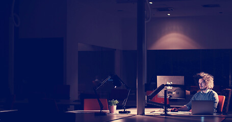 Image showing man working on computer in dark office