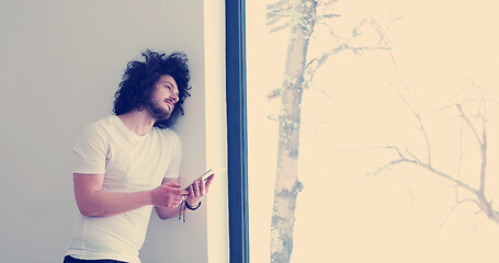 Image showing young man using a tablet at home