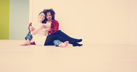 Image showing Young Couple using digital tablet on the floor