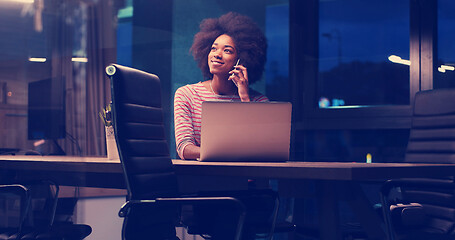 Image showing black businesswoman using a laptop in night startup office