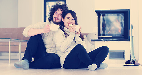 Image showing multiethnic romantic couple  in front of fireplace