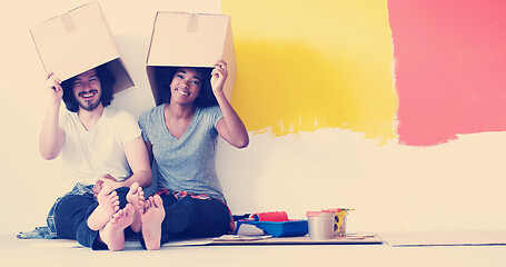 Image showing young multiethnic couple playing with cardboard boxes