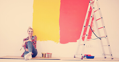 Image showing young female painter sitting on floor