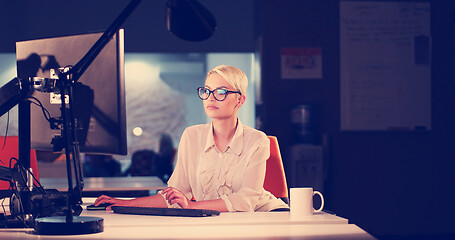 Image showing woman working on computer in dark office