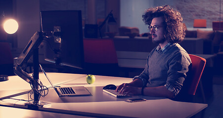 Image showing man working on computer in dark office