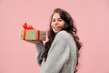 Image showing Woman with big beautiful smile holding colorful gift box.